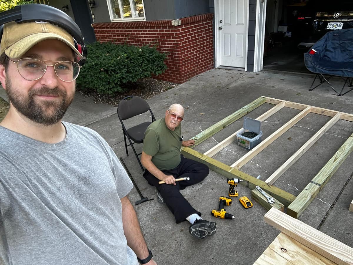 Ben and his dad beside the framed coop floor on the driveway.