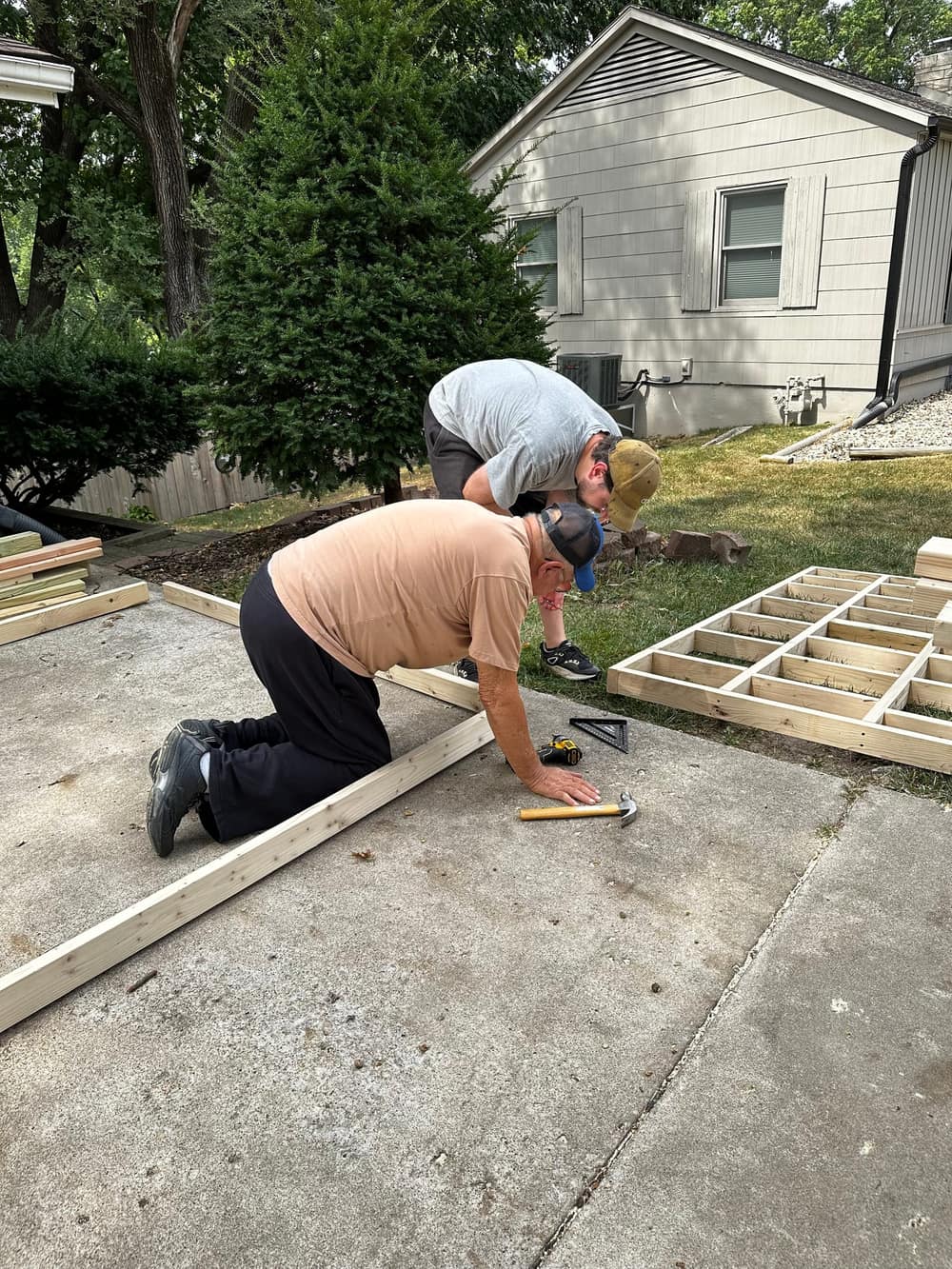 Ben and his dad kneeling together over the framing.